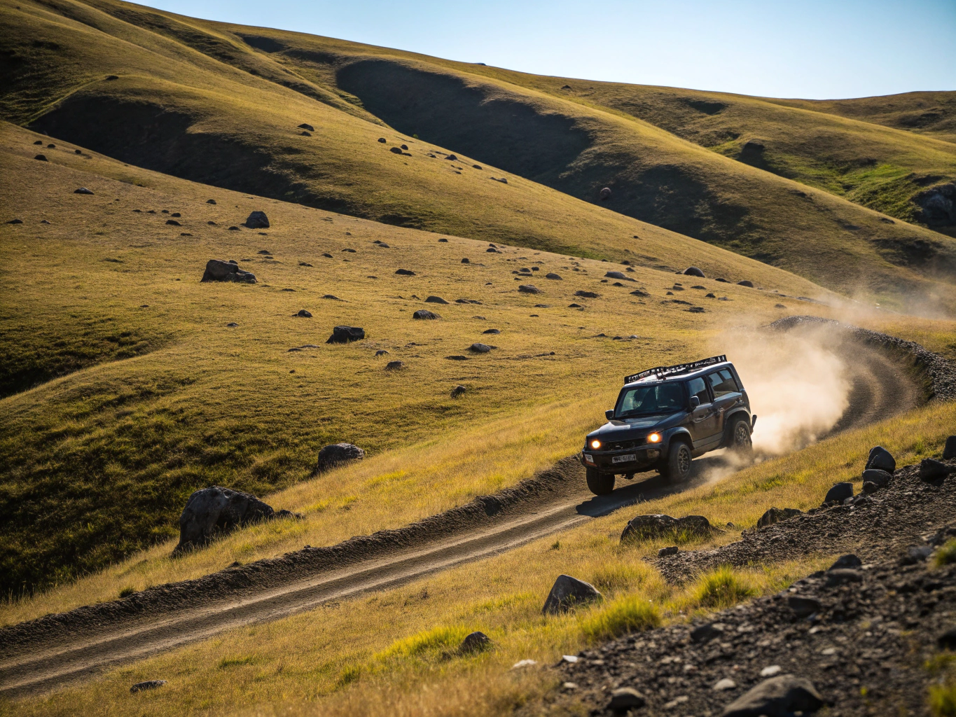 4x4 vehicle climbing a rocky ridge at sunset